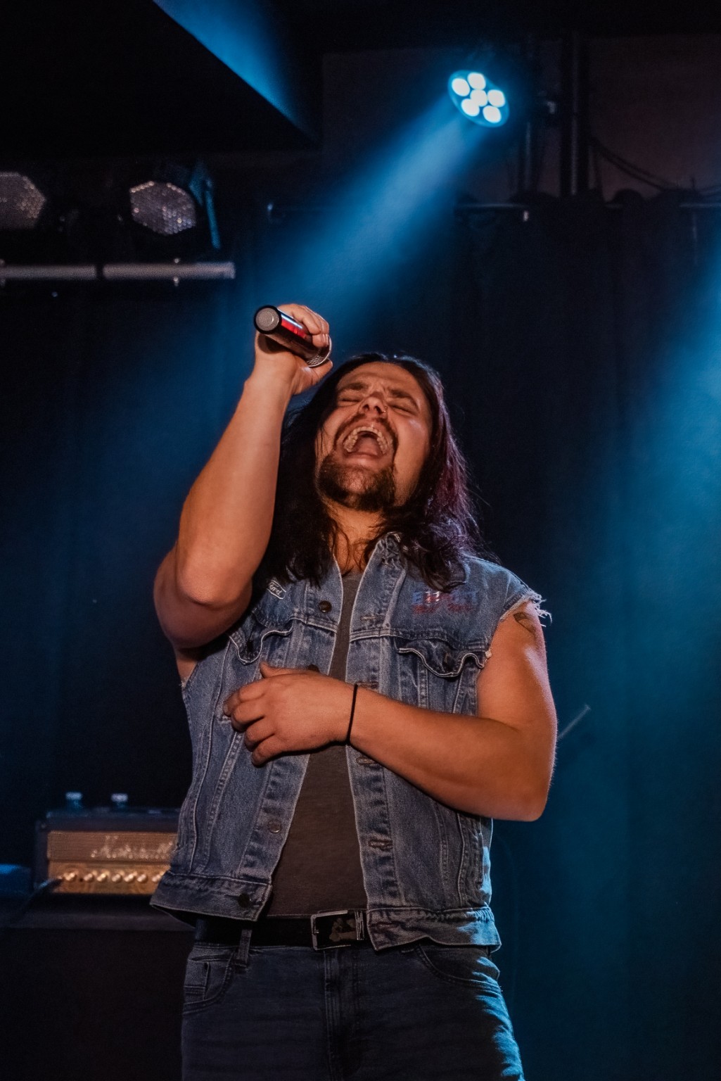 AC/DC ERAS vocalist performing under blue stage lights