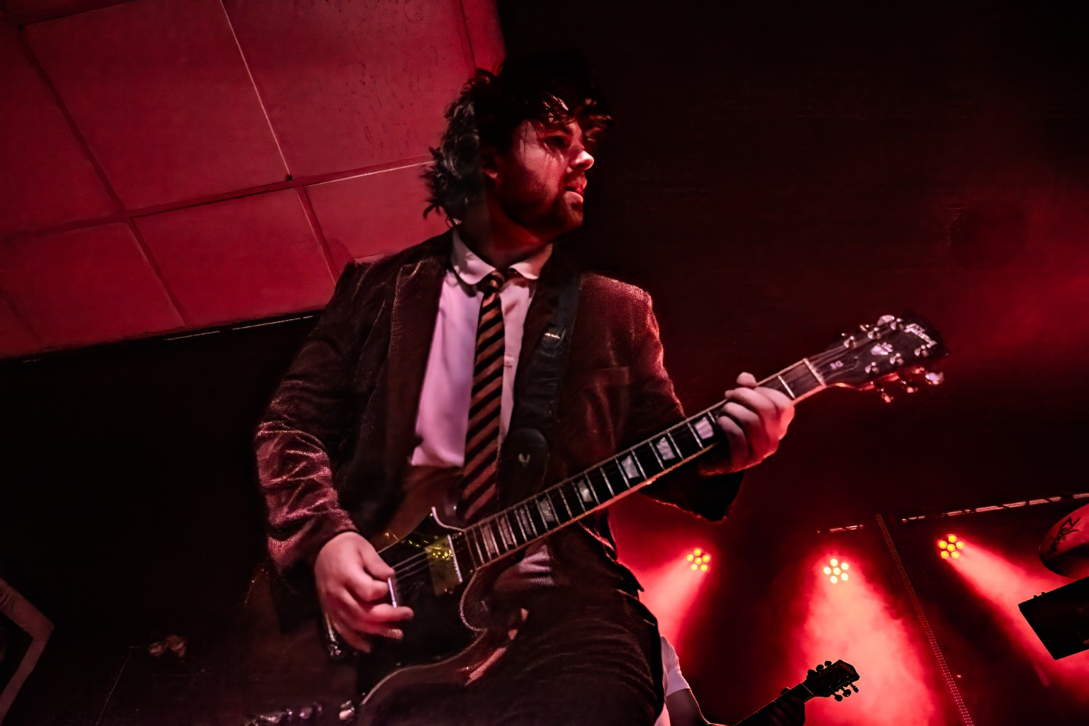 AC/DC ERAS guitarist under red stage lights